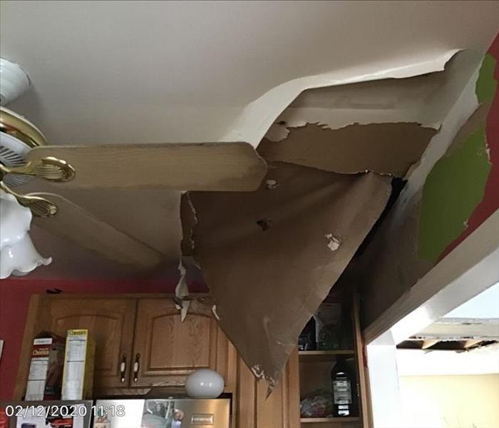 multiple layers of building material crumbling and peeling falling from a kitchen ceiling, in Middle River, MD